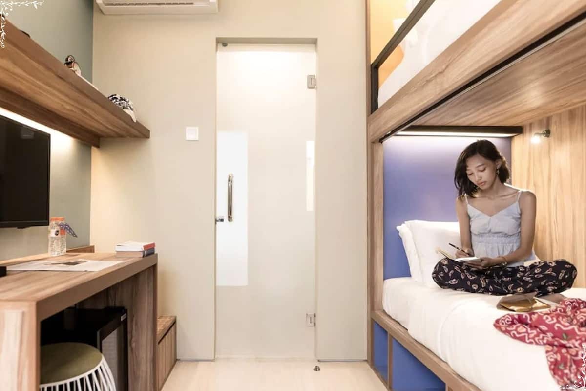 A compact room with a bed, a desk, and a television.