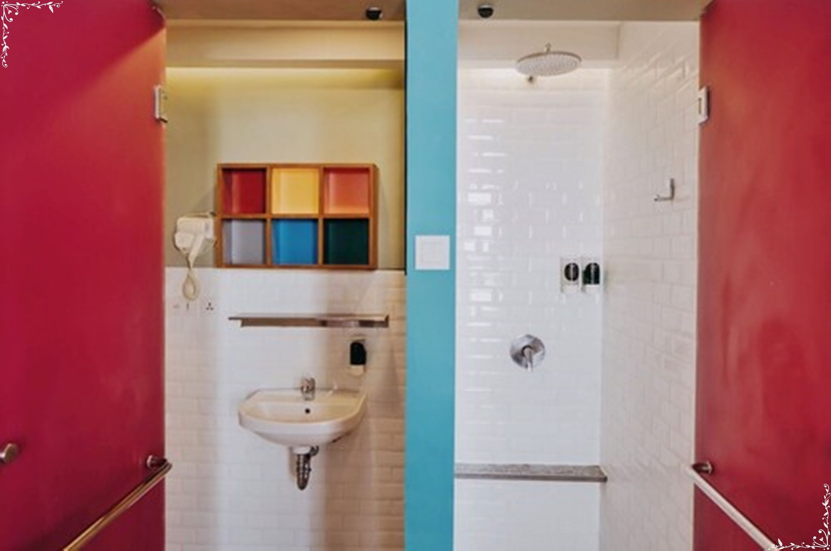 A bathroom with a sink, mirror, and colorful storage boxes.
