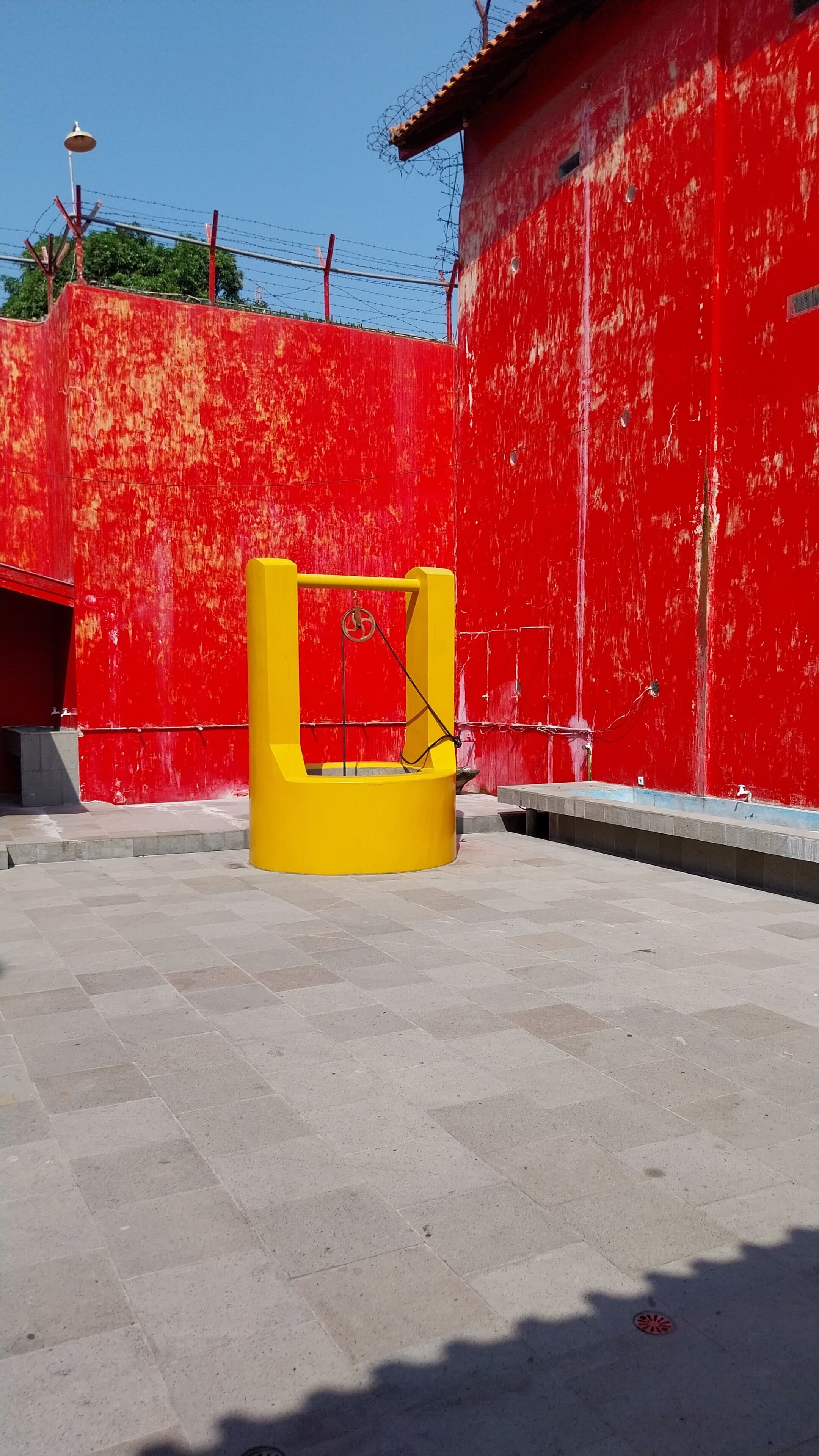 A red building with a yellow structure in front.