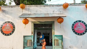 A building entrance with two green doors, a tiled roof, and traditional lanterns.