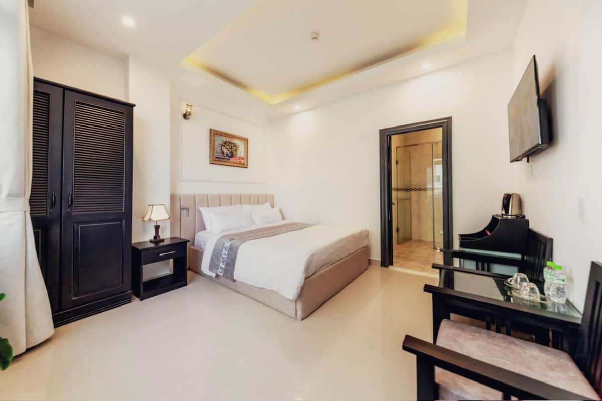 Une chambre à coucher moderne, comprenant un lit, une table de chevet, une lampe et un bureau avec une chaise.