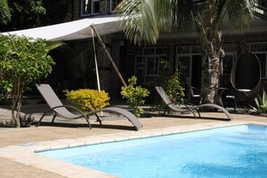 Una piscina cubierta, una piscina al aire libre, tumbonas