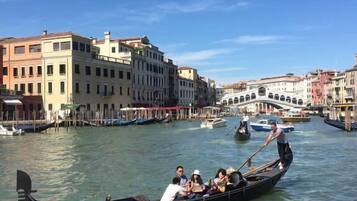 A gondola with passengers on a canal in a historic city.