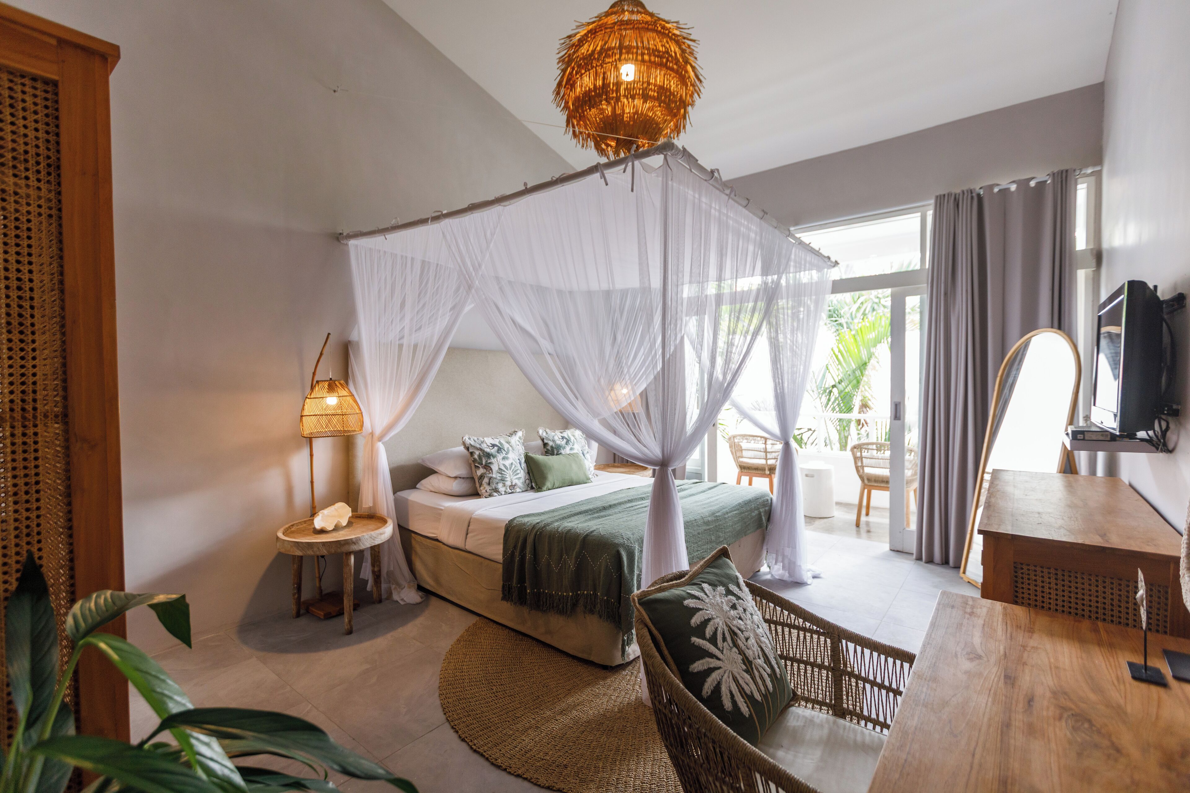 A bedroom with a bed, bedside table, lamp, and a large window.