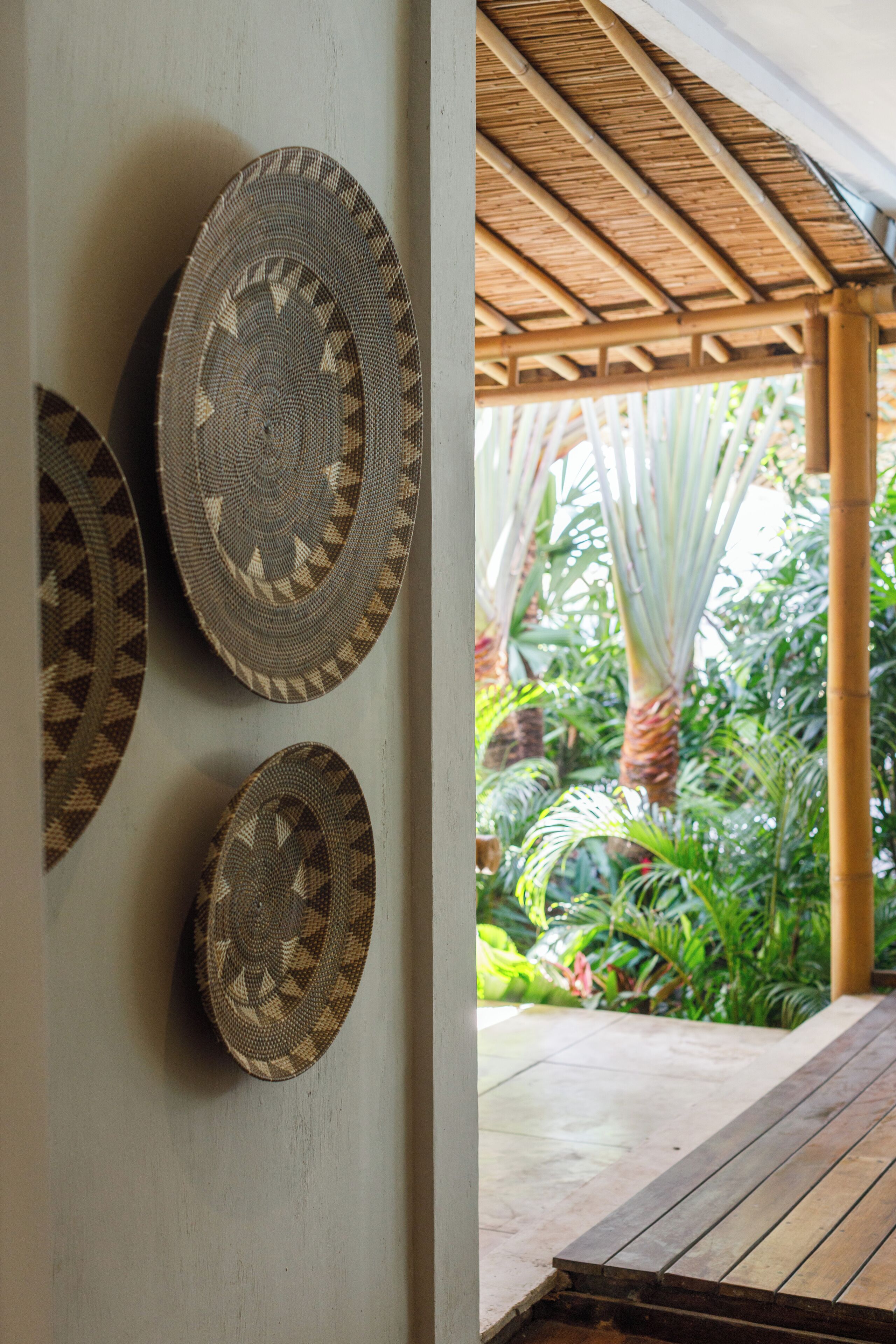 A room with a bamboo ceiling and a view of lush greenery outside.
