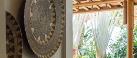 A room with a bamboo ceiling and a view of lush greenery outside.