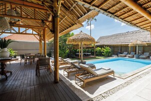 Una piscina al aire libre, sillones reclinables de piscina