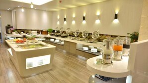 A modern buffet setup with multiple serving stations, including a salad bar and beverage dispensers.