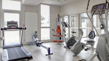 A gym with treadmills, elliptical machines, and weight equipment.