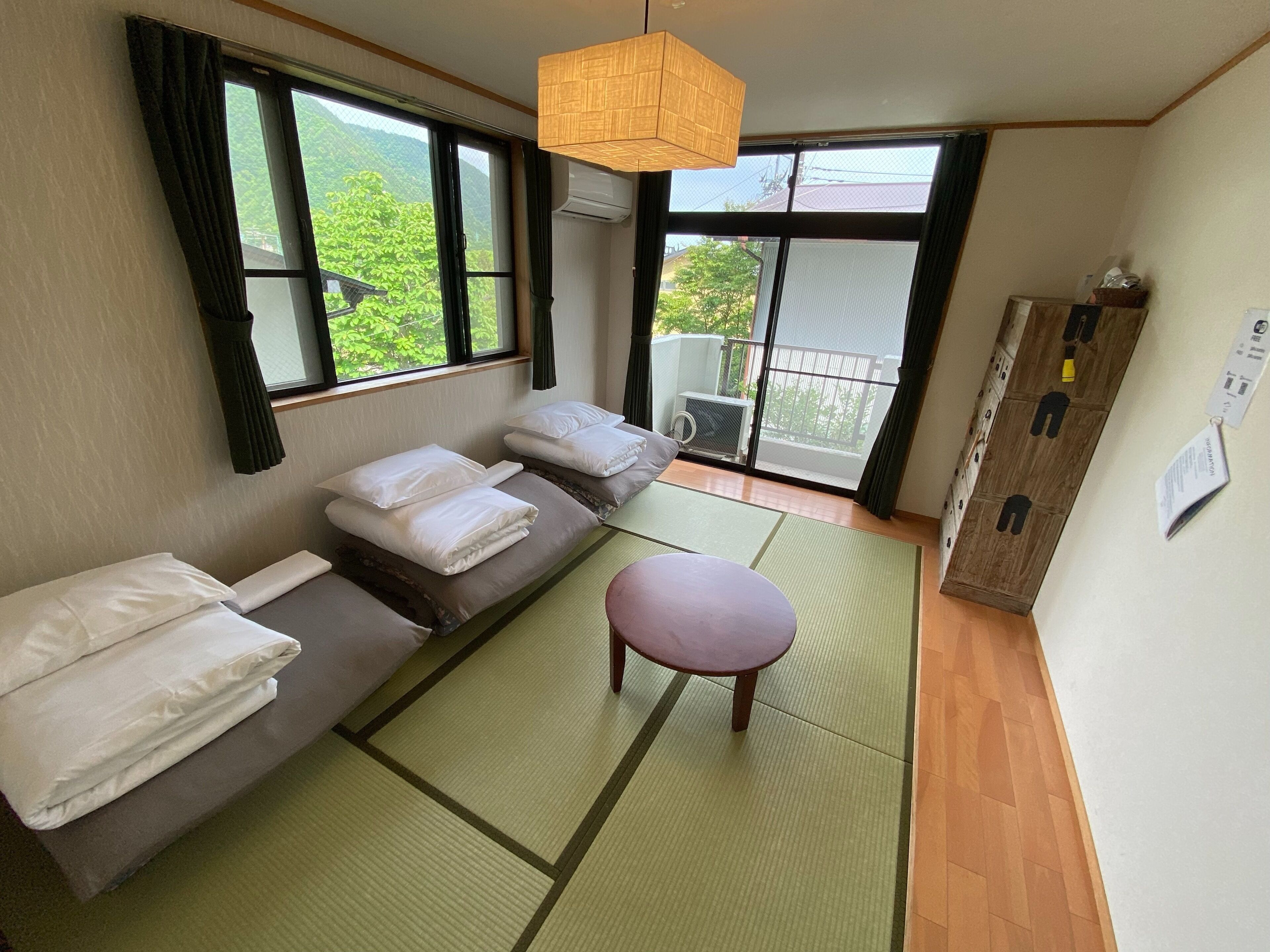 A room with tatami mats, a low table, and a sofa with pillows.
