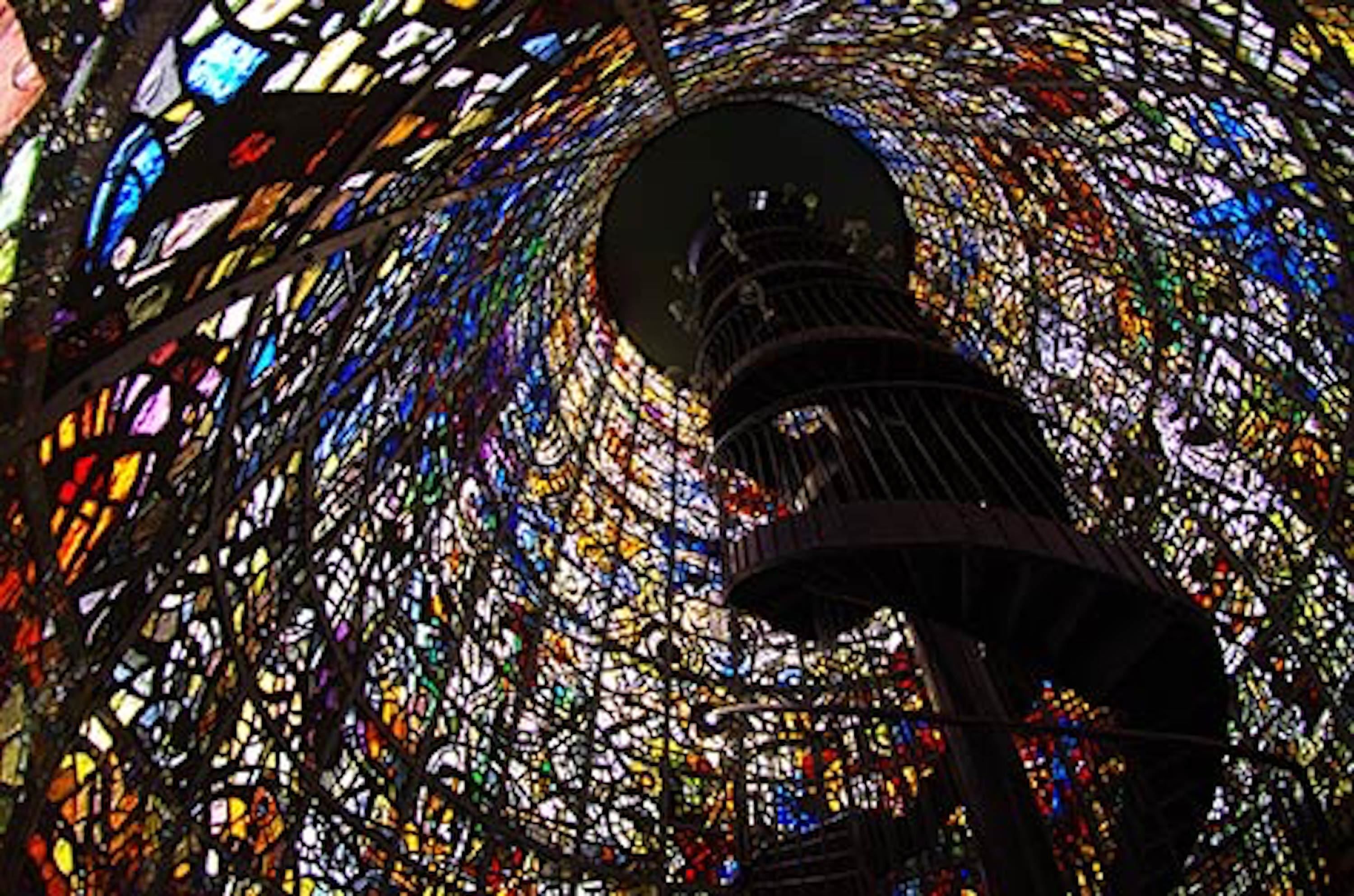 Een rond gebouw met glas-in-lood en ingewikkelde patronen, met een centrale opening.