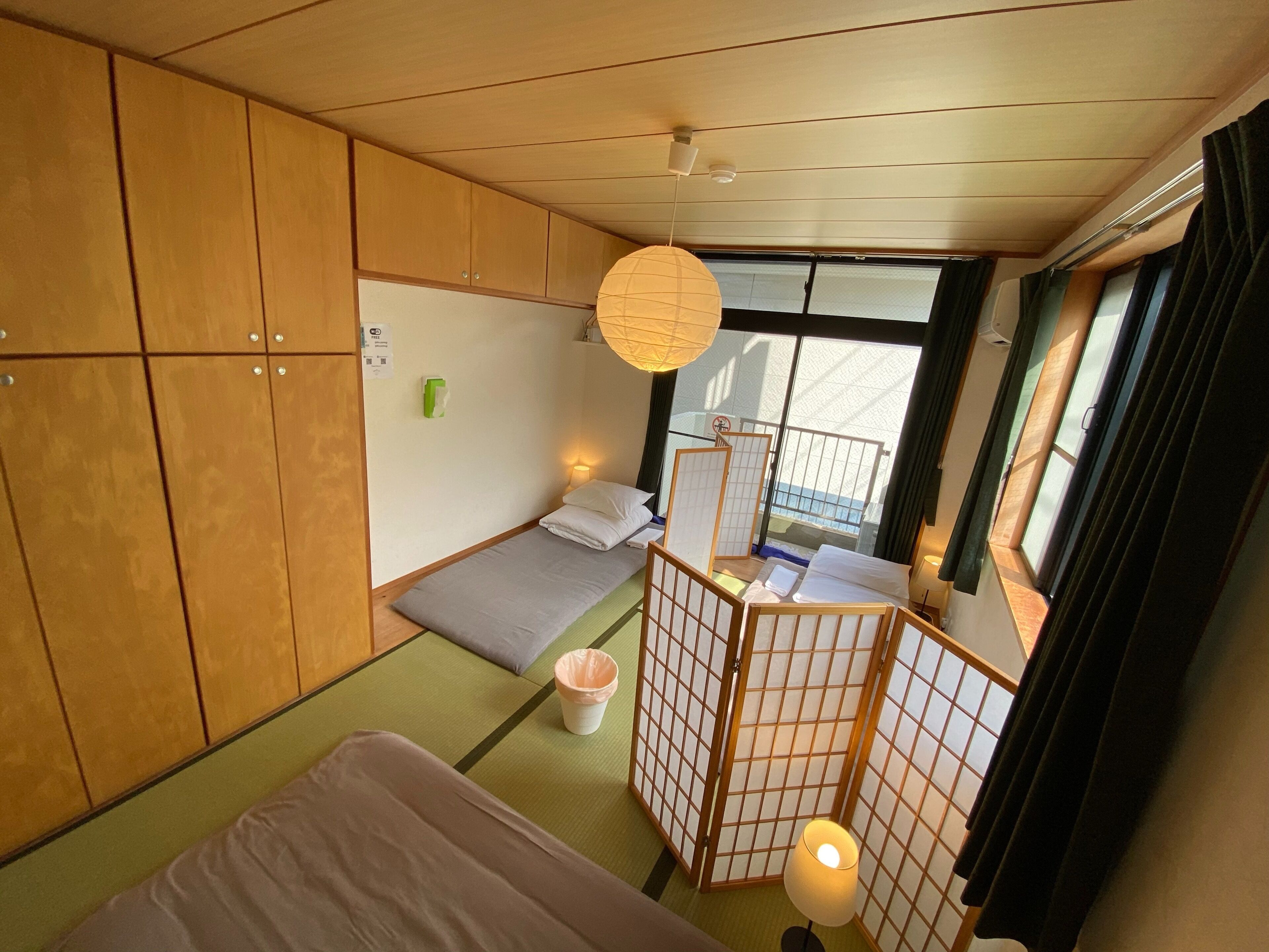 Una habitación pequeña con una cama, un escritorio, una silla y una ventana.