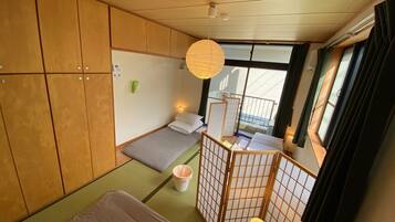 Una habitación pequeña con una cama, un escritorio, una silla y una ventana.