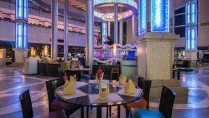 A spacious lobby with a central circular light fixture, multiple seating areas, and a reception desk. - Ambassador City Jomtien Pattaya - Garden Wing (Sattahip)