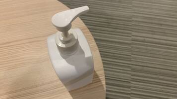 A white pump bottle on a wooden surface.