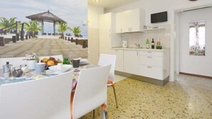 A modern kitchen with white cabinets and a flat-screen TV. - Mario Apartment 2 (Venice)