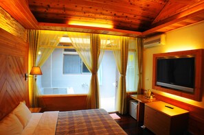 A wooden cabin room with a bed, a TV, and a window with curtains. - Ying Su Health Spa Hotel (Ren'ai)