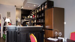Eine Bar mit Theke, Flaschenregalen und einer Sitzecke mit Tisch und Stühlen.