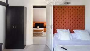 Ein Schlafzimmer mit einem Bett, einem Kleiderschrank und einer Couch im Hintergrund.