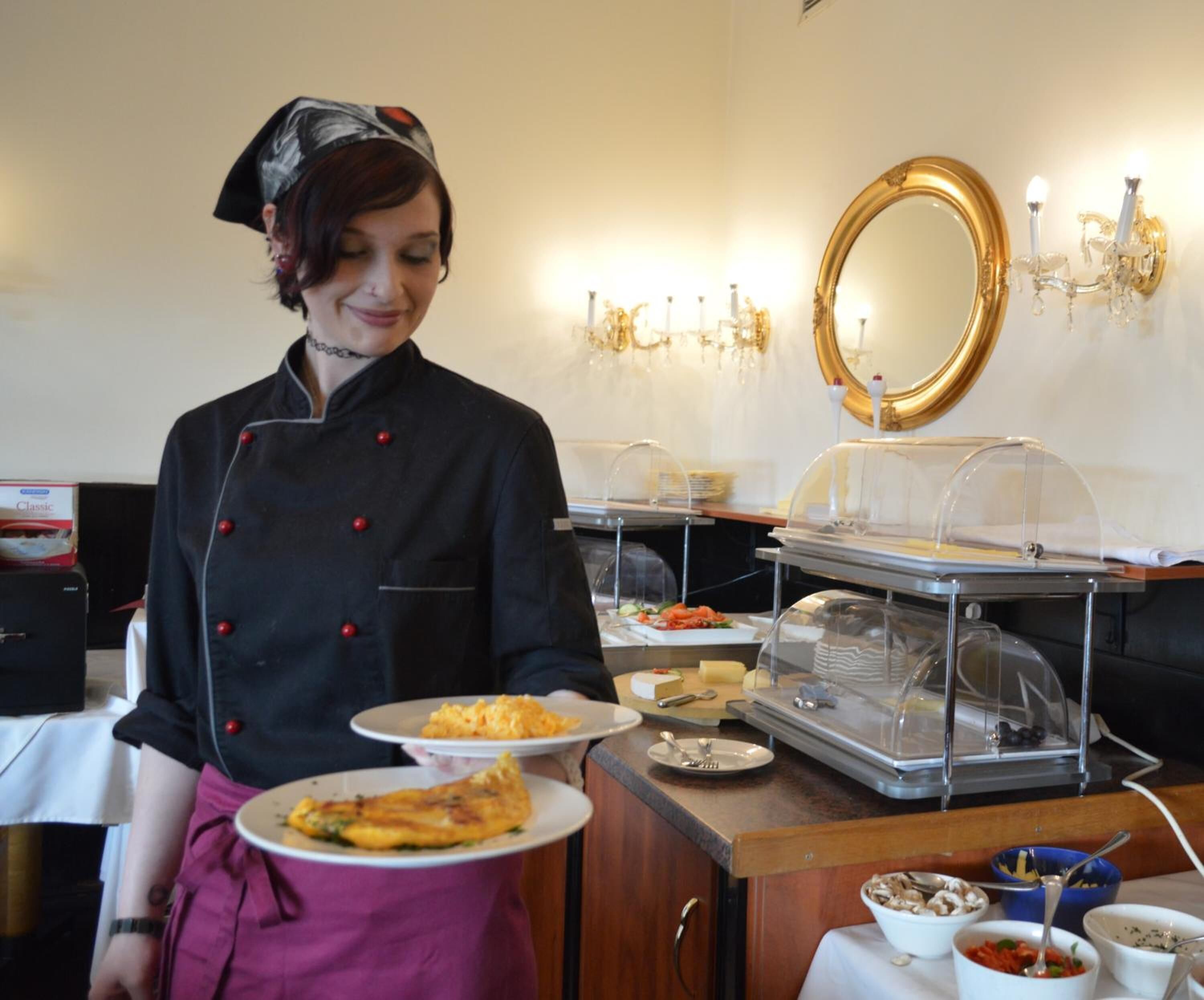 Montaje tipo buffet con diversos alimentos y una persona sirviendo.