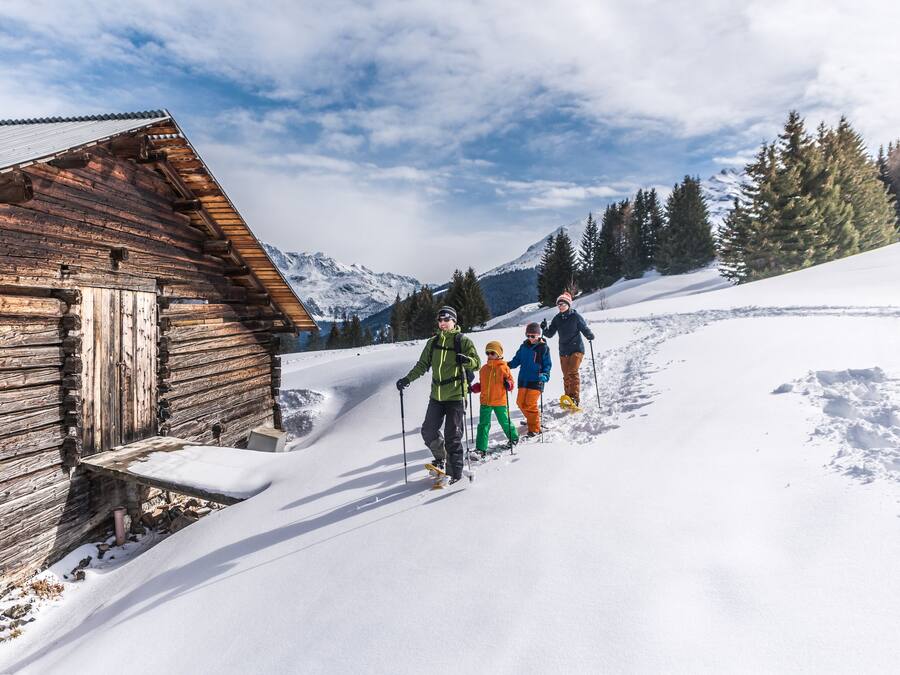 Una cabaña de madera rústica con suelo cubierto de nieve y un cielo despejado.
