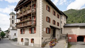 A traditional building with a balcony, a bell tower, and a sign for 'LANZIO BAR'. - Hotel Post Bivio (Surses)