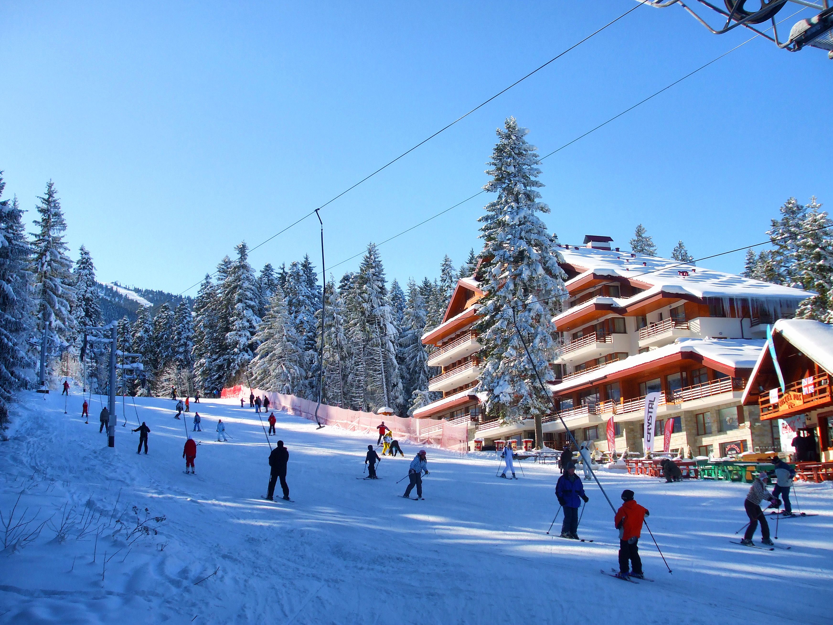 Una stazione sciistica con diversi edifici, piste da sci e alberi innevati.