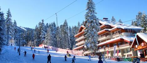 A ski resort with multiple buildings, ski slopes, and snow-covered trees.
