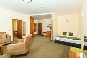 A hotel room with a bed, a sofa, a chair, a desk, and a mirror. - Club Hotel Yanakiev (Samokov)