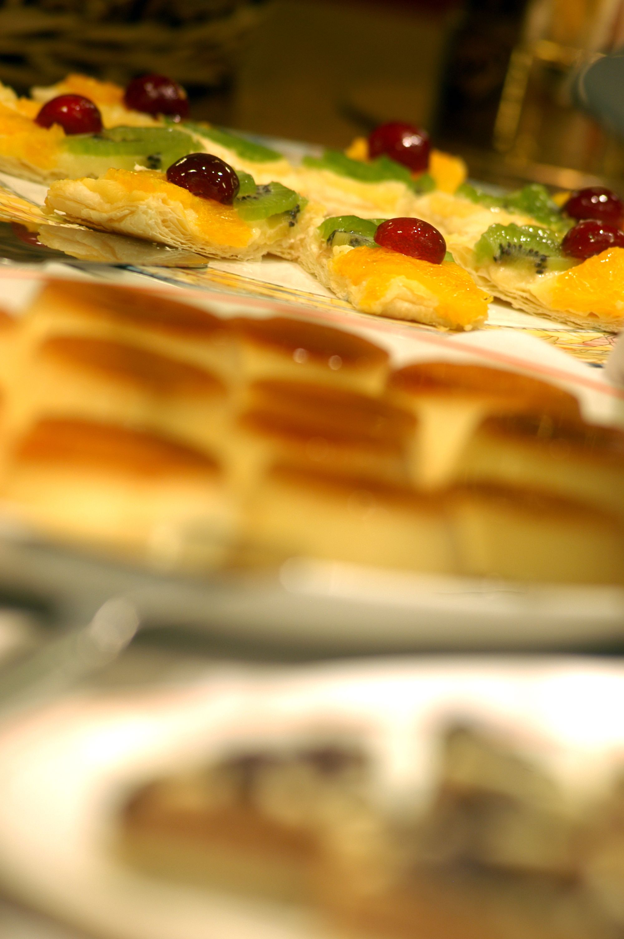 Primer pla d'una safata de postres amb diferents fruites i un pastís en capes.