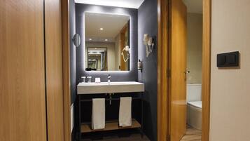 Un baño moderno con tocador, espejo y perchero.