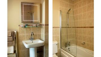 A bathroom with a sink, mirror, and shower.