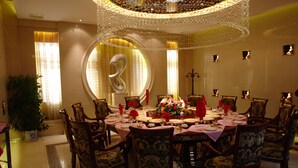 Un comedor formal con una mesa redonda dispuesta para ocho personas, rodeada de sillas ornamentales.