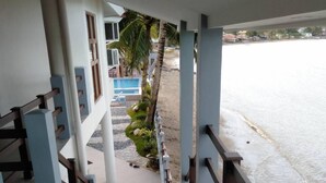 A staircase leading to a beach area with a pool and palm trees. - Nirvana Resort (Puerto Galera)