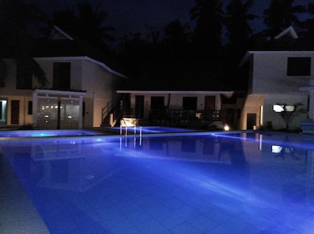 Una piscina al aire libre, sillones reclinables de piscina. Nirvana Resort