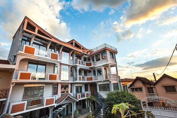 A multi-story building with balconies, staircases, and a mix of windows and doors.