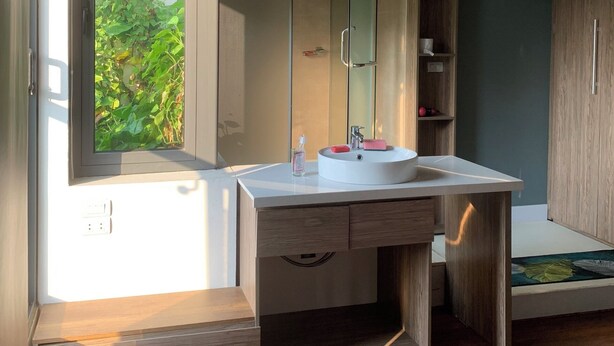 A modern bathroom with a large mirror, a sink, and a shower enclosure. - Unique Serviced Apartment (Hanoi)