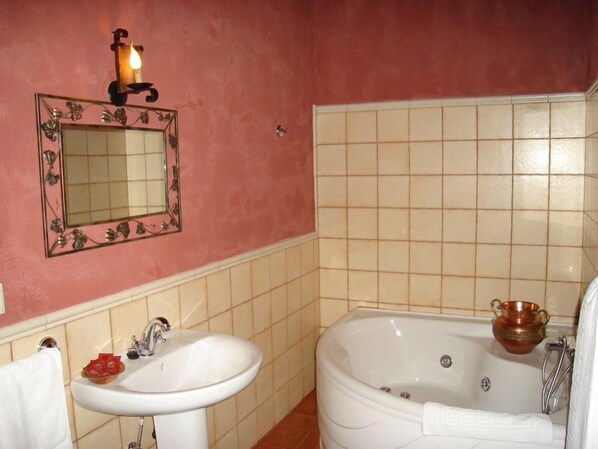 A bathroom with a sink, mirror, and bathtub. - Cortijo Molino Los Justos (Algarinejo)