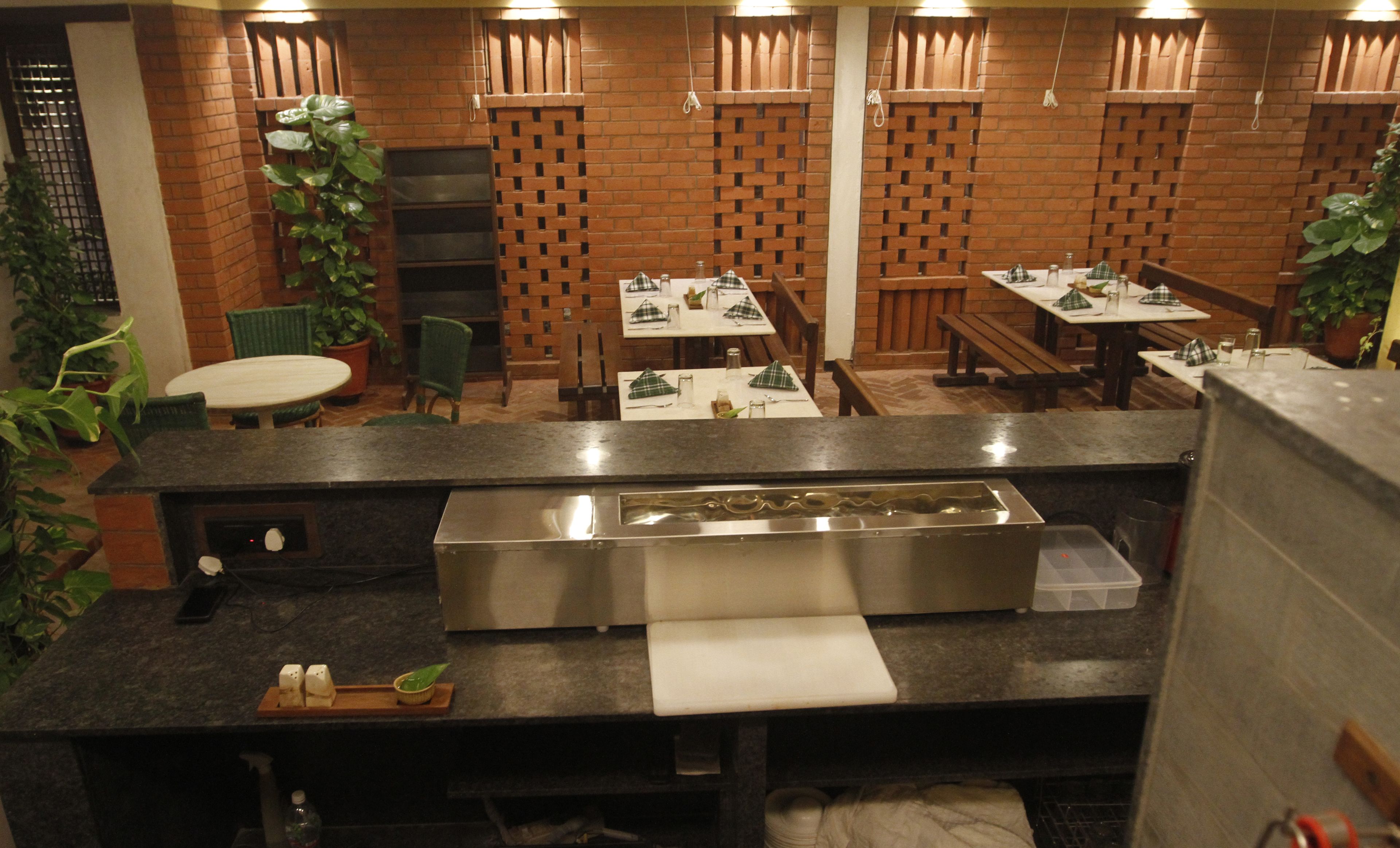 A restaurant with brick walls, wooden furniture, and a long counter.