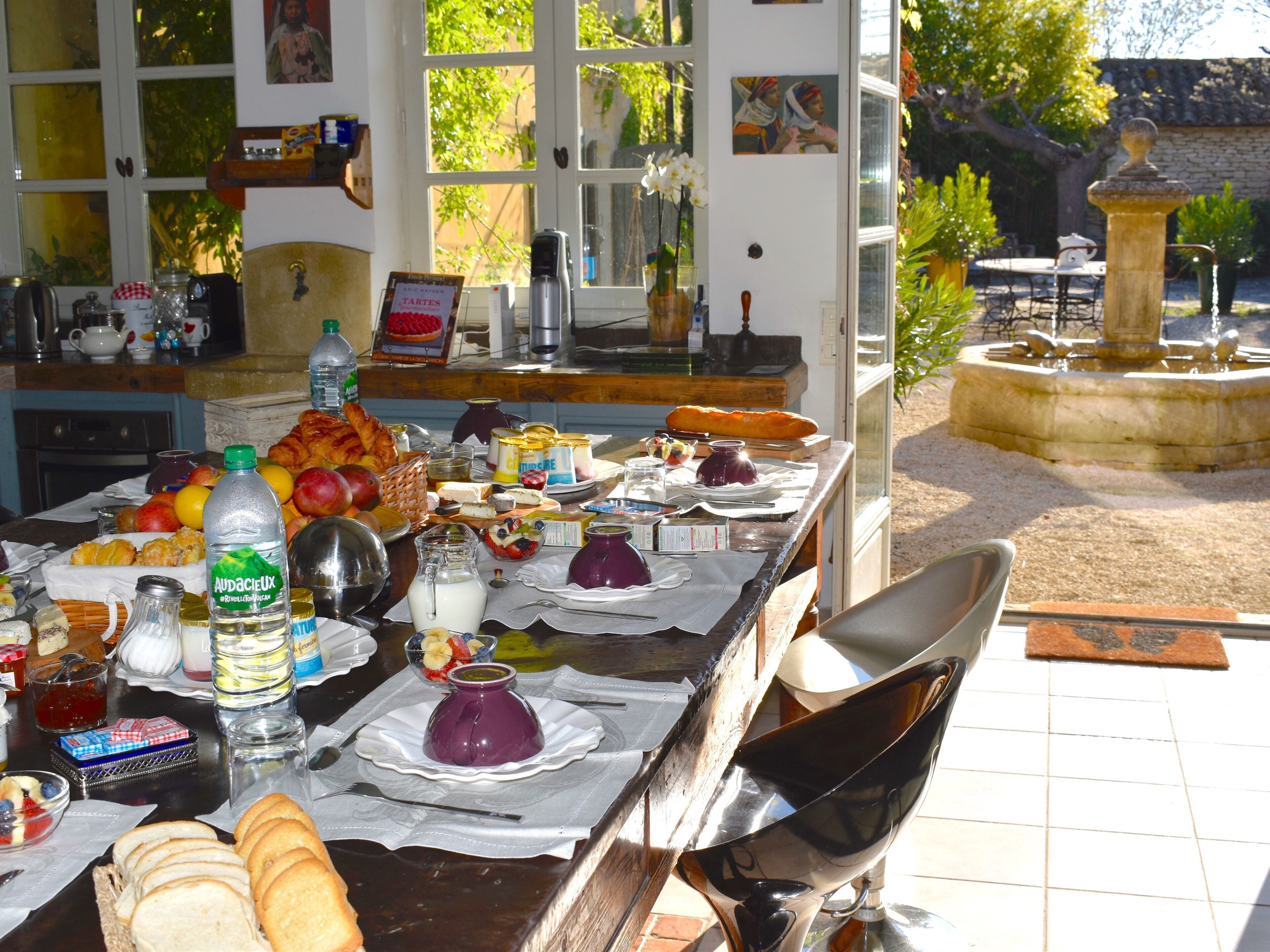 A table set for breakfast with various food items and a bottle of water.