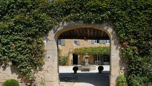 Une entrée en arc de cercle, avec un chemin de gravier menant à un bâtiment.