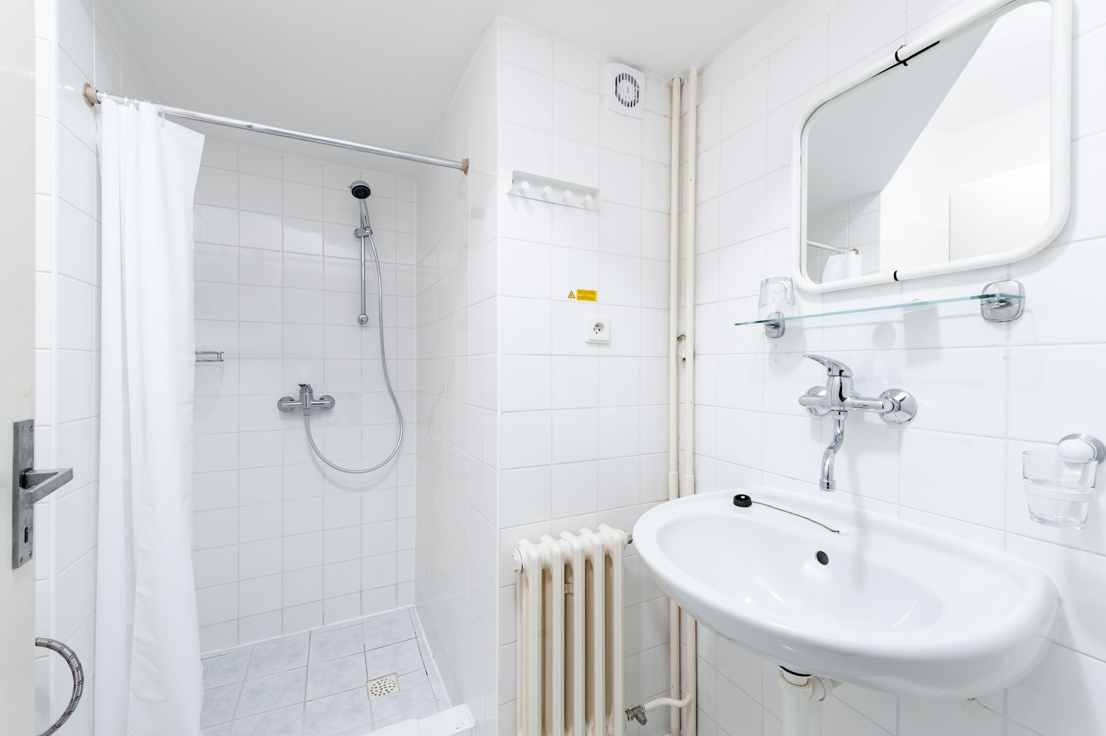 Ein modernes Badezimmer mit Dusche, Waschbecken und Spiegel.
