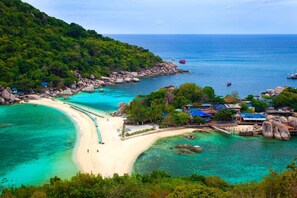 Une station balnéaire dotée d’une plage de sable, d’eaux turquoise et limpides, et d’une végétation luxuriante.