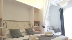 A neatly made bed with pillows, a bedside table, and a hanging light fixture. - My Rooms Ciutadella - Adults Only by My Rooms Hotels (Ciutadella de Menorca)