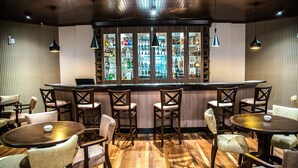 A bar area with wooden flooring, multiple bar stools, and a bar counter with a wine rack. - Gaboardi Park Hotel (Curitibanos)