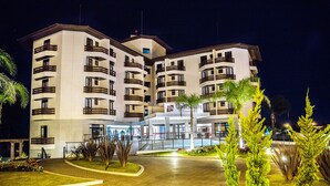 A multi-story hotel with a central courtyard, balconies, and a well-lit entrance. - Gaboardi Park Hotel (Curitibanos)