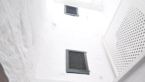 A narrow alleyway with white walls and black shutters. - Port Antic Ciutadella  by My Rooms Hotels (Ciutadella de Menorca)