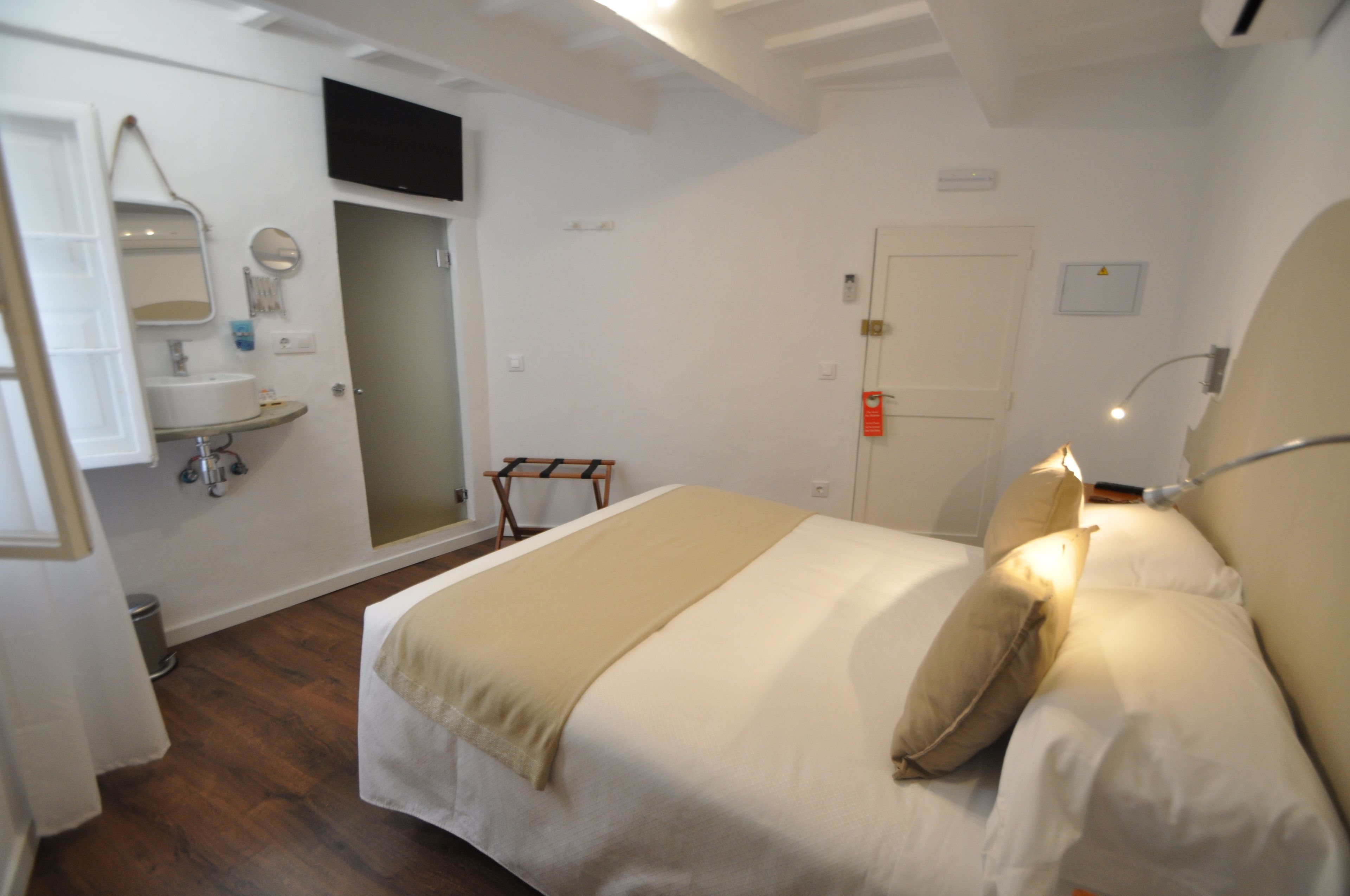 A bedroom with a bed, bedside lamp, and a small bedside table.