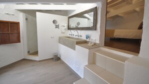 A modern bathroom with a large mirror, a sink, and a shower area. - Port Antic Ciutadella  by My Rooms Hotels (Ciutadella de Menorca)
