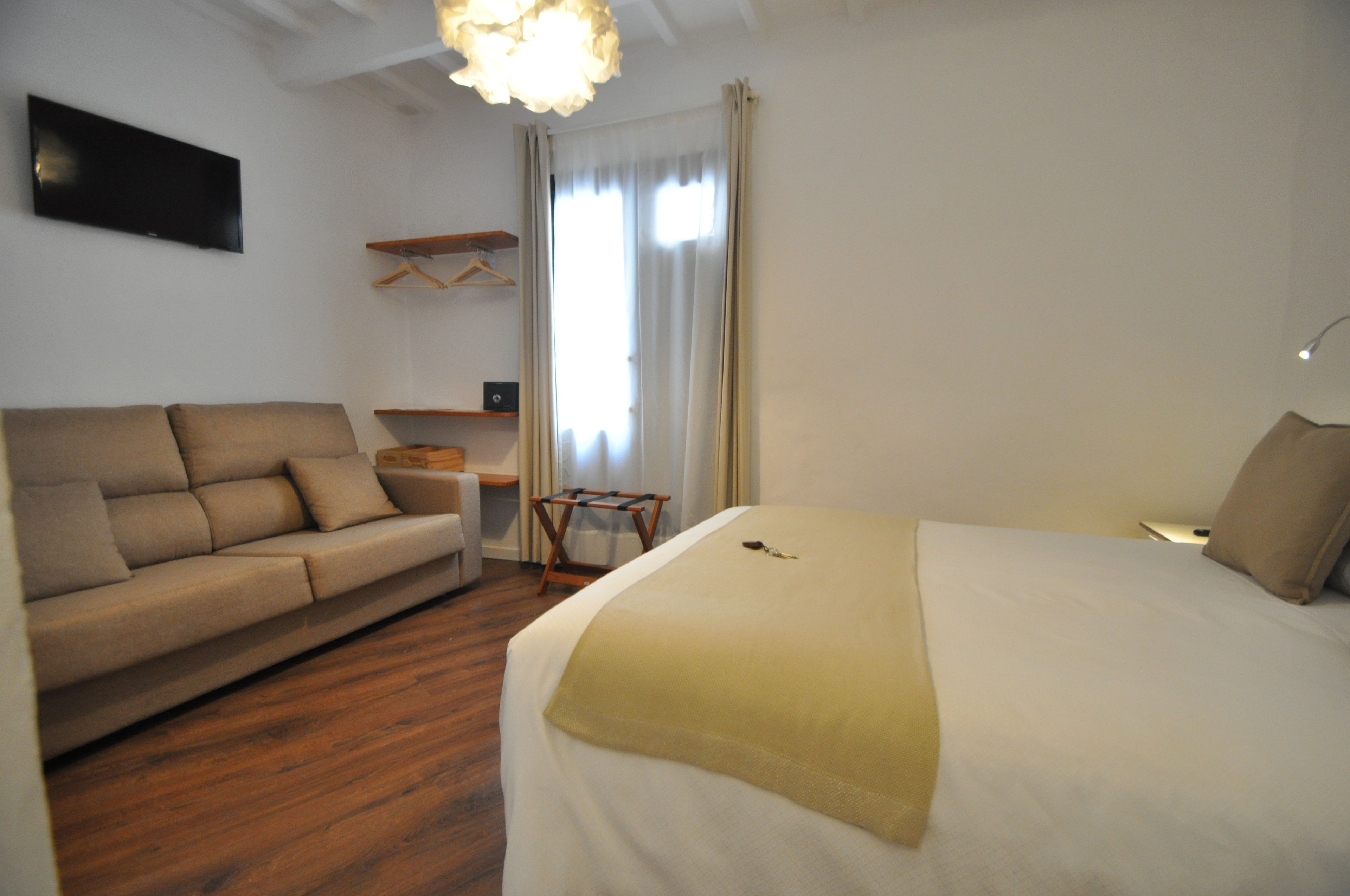 Een hotelkamer met een bed, een bank, een bureau en een televisie.